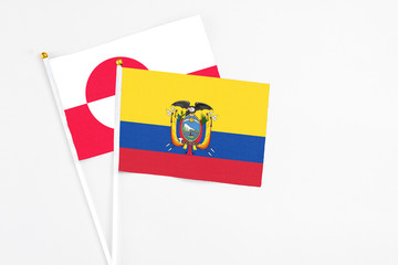 Ecuador and Greenland stick flags on white background. High quality fabric, miniature national flag. Peaceful global concept.White floor for copy space.