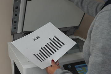 Young woman making photocopies of a chart