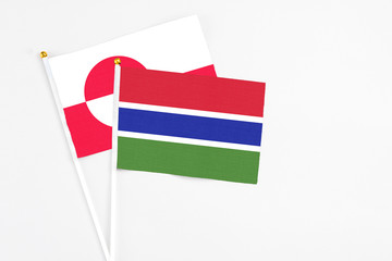 Gambia and Greenland stick flags on white background. High quality fabric, miniature national flag. Peaceful global concept.White floor for copy space.