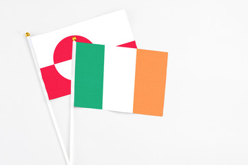 Ireland and Greenland stick flags on white background. High quality fabric, miniature national flag. Peaceful global concept.White floor for copy space.