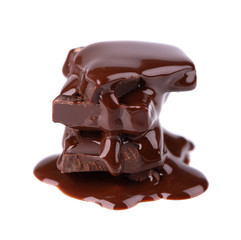 Chocolate pieces stack and chocolate syrup isolated on white background. Close up.