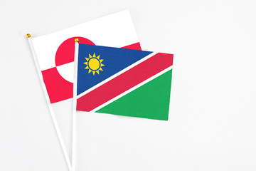 Namibia and Greenland stick flags on white background. High quality fabric, miniature national flag. Peaceful global concept.White floor for copy space.