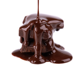 Chocolate pieces stack and chocolate syrup isolated on white background. Close up.