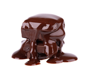 Chocolate pieces stack and chocolate syrup isolated on white background. Close up.