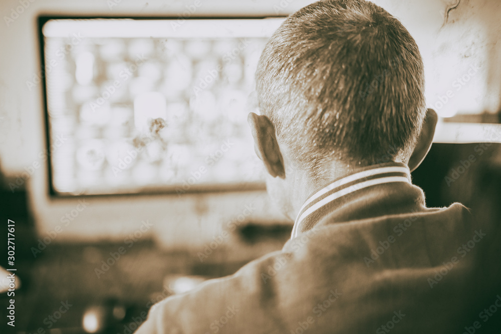 Poster man working at home computer in front of big screen