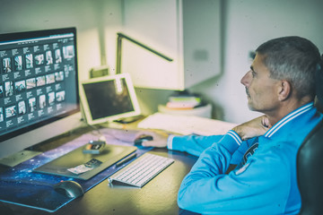 Obraz premium Man working at home computer in front of big screen