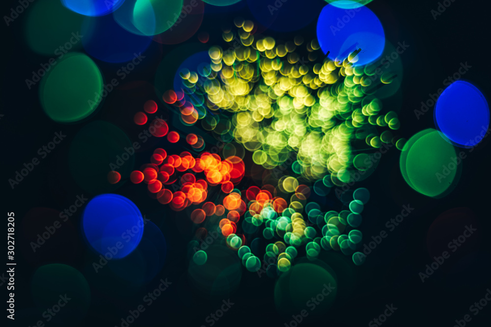 Poster beautiful multi colored abstract optical light bokeh on a dark background.