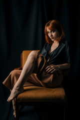Fototapeta na wymiar Young woman in dress sitting on a chair