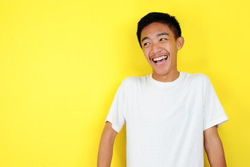 Handsome young Asian man smiling. Close up portrait of a handsome young Asian man smiling look at...