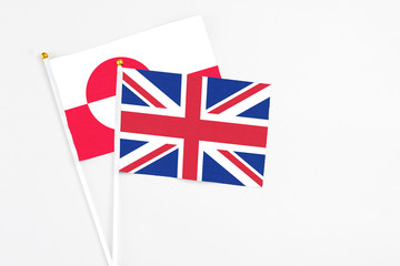 United Kingdom and Greenland stick flags on white background. High quality fabric, miniature national flag. Peaceful global concept.White floor for copy space.