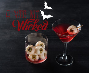 red decorated Halloween cocktail on black background with a wee bit wicked illustration