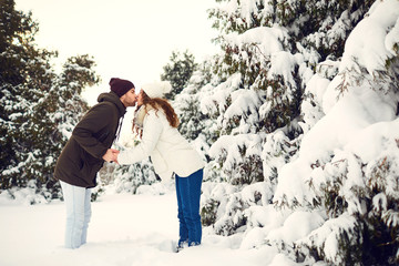 Man and woman kissing in snowy forest