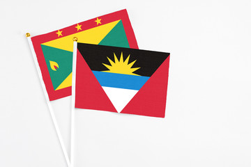 Antigua and Barbuda and Grenada stick flags on white background. High quality fabric, miniature national flag. Peaceful global concept.White floor for copy space.