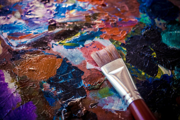 A palette with paints, oil and acrylic. Bright colors, palette knife and brush.