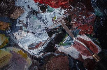 A palette with paints, oil and acrylic. Bright colors, palette knife and brush.