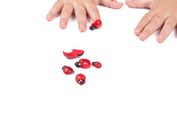 Red ladybug and children's hand isolated on white background
