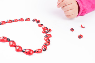 Obraz premium Red ladybug and children's hand isolated on white background