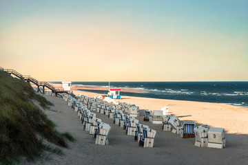Beach landscape with wicker chairs in the morning on Sylt island