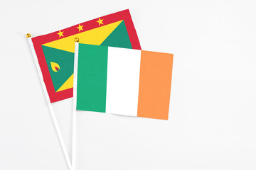 Ireland and Grenada stick flags on white background. High quality fabric, miniature national flag. Peaceful global concept.White floor for copy space.