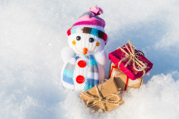toy snowman with gifts in a snowdrift