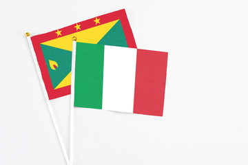 Italy and Grenada stick flags on white background. High quality fabric, miniature national flag. Peaceful global concept.White floor for copy space.