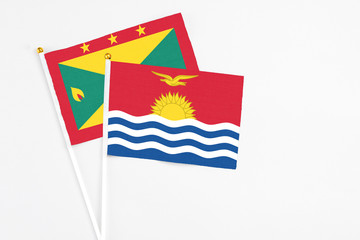 Kiribati and Grenada stick flags on white background. High quality fabric, miniature national flag. Peaceful global concept.White floor for copy space.
