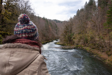 Chica mirando a r&iacute;o en bosque de oto&ntilde;o