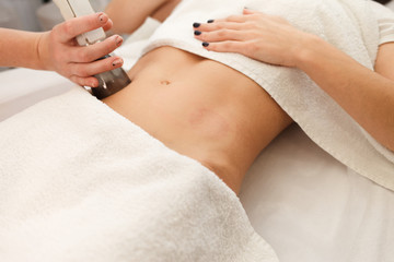 Doctor makes a vacuum massage procedure of the abdomen. Anti- cellulite body correction treatment