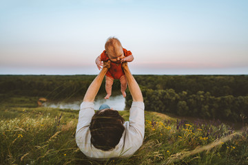 Father and baby daughter laying on grass outdoors family lifestyle dad and infant child walking together summer vacations  parenthood childhood concept Fathers day holiday