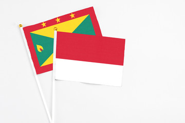 Monaco and Grenada stick flags on white background. High quality fabric, miniature national flag. Peaceful global concept.White floor for copy space.