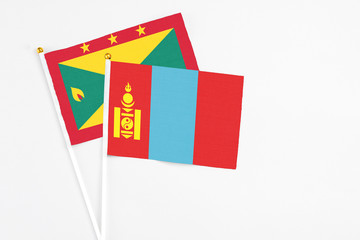 Naklejka premium Mongolia and Grenada stick flags on white background. High quality fabric, miniature national flag. Peaceful global concept.White floor for copy space.