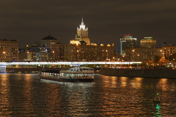 Fototapeta premium Moscow downtown architecture in night. Ministry of Foreign Affairs (MFA) in distance. Moskva river is full of city lights reflections.