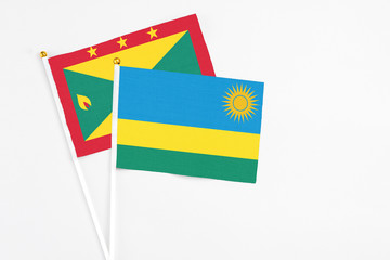 Rwanda and Grenada stick flags on white background. High quality fabric, miniature national flag. Peaceful global concept.White floor for copy space.