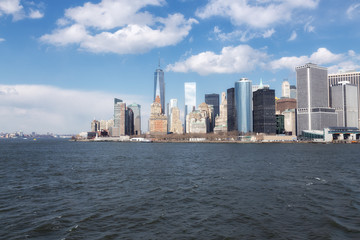 Manhattan midtown skyline panorama over East River with urban skyscrapers and blue sky with clouds in New York City