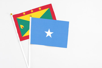 Somalia and Grenada stick flags on white background. High quality fabric, miniature national flag. Peaceful global concept.White floor for copy space.