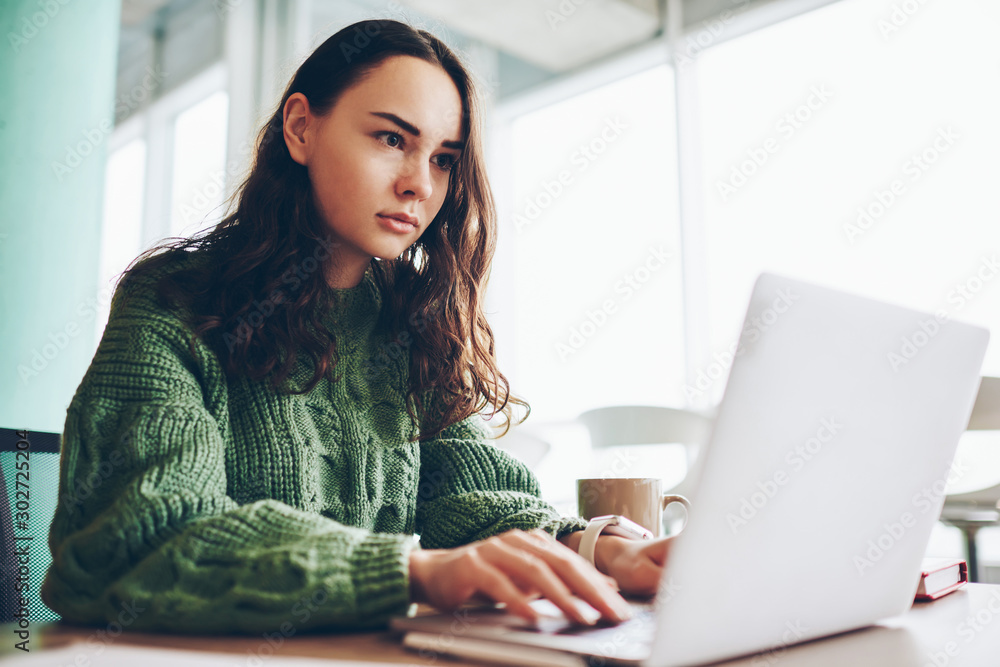 Poster pensive caucasian millennial girl learning during online courses on laptop computer during free time