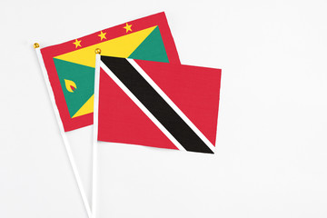 Trinidad And Tobago and Grenada stick flags on white background. High quality fabric, miniature national flag. Peaceful global concept.White floor for copy space.