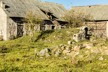 Late autumn. Yard of an old abandoned farm. Ruined barns and a cellar, like a cave. Former dairy industry. Podlasie, Poland.
