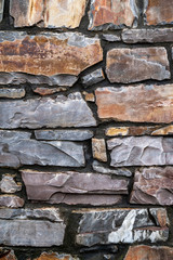 Stone wall. The wall is made of wild stone. Stone background.