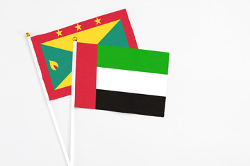 United Arab Emirates and Grenada stick flags on white background. High quality fabric, miniature national flag. Peaceful global concept.White floor for copy space.