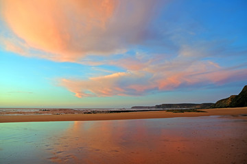 Beautiful cloudscape at Praia Vale Figueiras in Portugal at sunset
