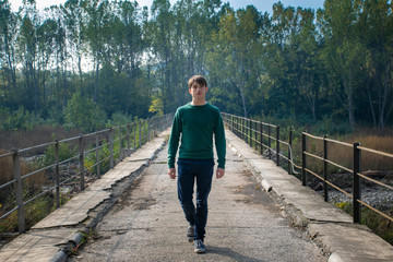 man walking in the middle of a bridge