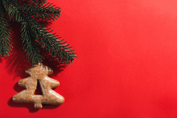 Christmas gingerbread in the shape of a Christmas tree on a red background, copy space.