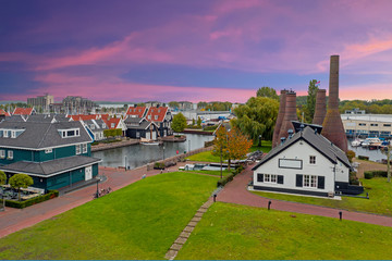 Aerial from traditional brick factory and houses in Huizen the Netherlands at sunset