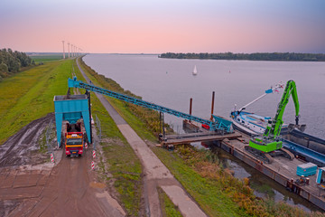 Fototapeta premium Aerial from freighter unloading sand in the countryside from the Netherlands