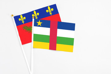 Central African Republic and Guadeloupe stick flags on white background. High quality fabric, miniature national flag. Peaceful global concept.White floor for copy space.