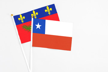 Chile and Guadeloupe stick flags on white background. High quality fabric, miniature national flag. Peaceful global concept.White floor for copy space.