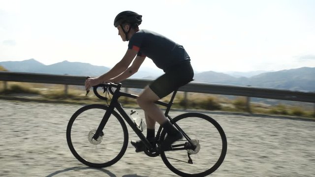 Cyclist enjoying biking mountain road Otago New Zealand