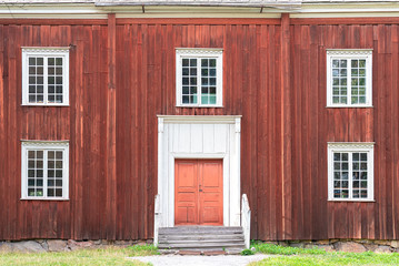Close up of square white windows in old red wooden barn wall, Sweden