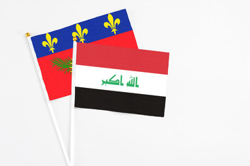 Iraq and Guadeloupe stick flags on white background. High quality fabric, miniature national flag. Peaceful global concept.White floor for copy space.